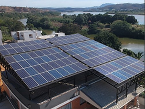 Estrutura com painéis solares sobre prédio comercial em Colatina, com o rio ao fundo
